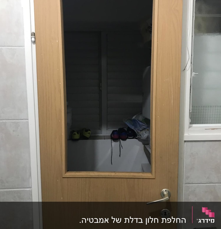 דלת עץ עם חלון זכוכית שקוף במרכז